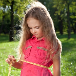 little girl measuring her waist